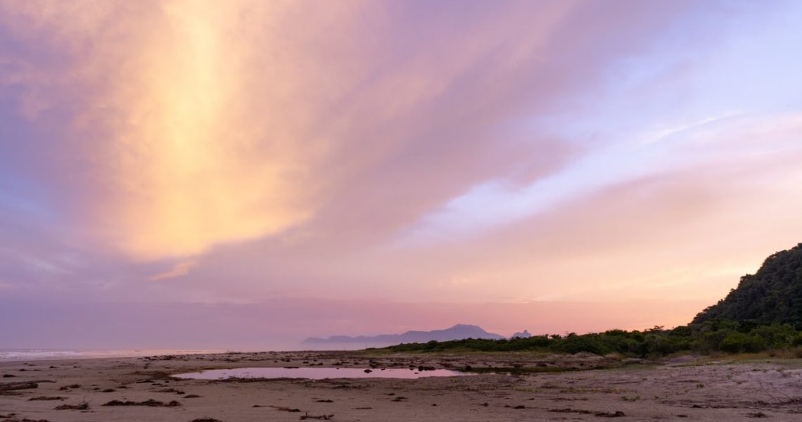 Stunning sunset view at Barra do Una beach, showcasing vibrant skies and serene coastline.